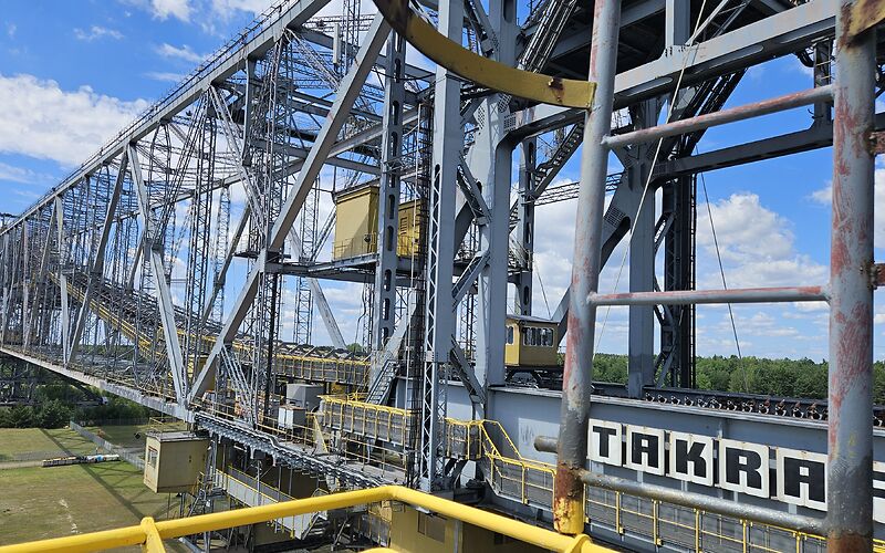 Die Förderbrücke F60 in Lichterfeld ist auf dem Foto zu sehen. Die beeindruckende Stahlkonstruktion zählt mit einer Länge von 502 Metern zu den größten beweglichen Maschinen der Welt.