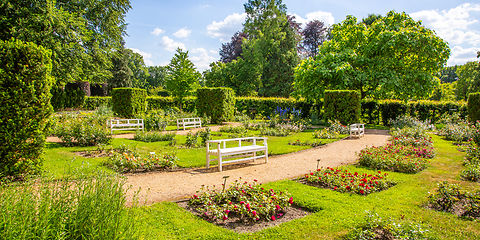 Garten der prämierten Schönheiten mit kleinen Rosenbeeten und eine weiße Parkbank