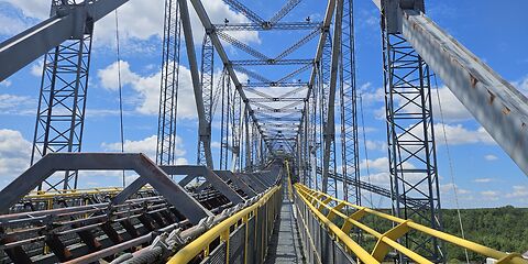 Auf dem Foto ist ein gesicherter Besucherweg auf der Förderbrücke F60 zu sehen. Die Geländer entlang des Weges sind für Besucher gelb markiert.
