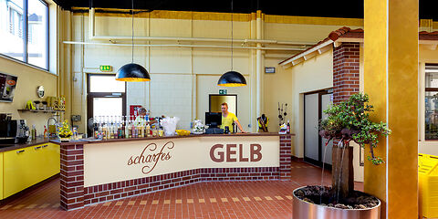 Die Eierlikörbar ‚scharfesGELB‘ mit der Kasse. Die Verkostung für individuelle Gäste findet hier statt. Die Einrichtung ist in Gelb, Braun und Schwarz gehalten.