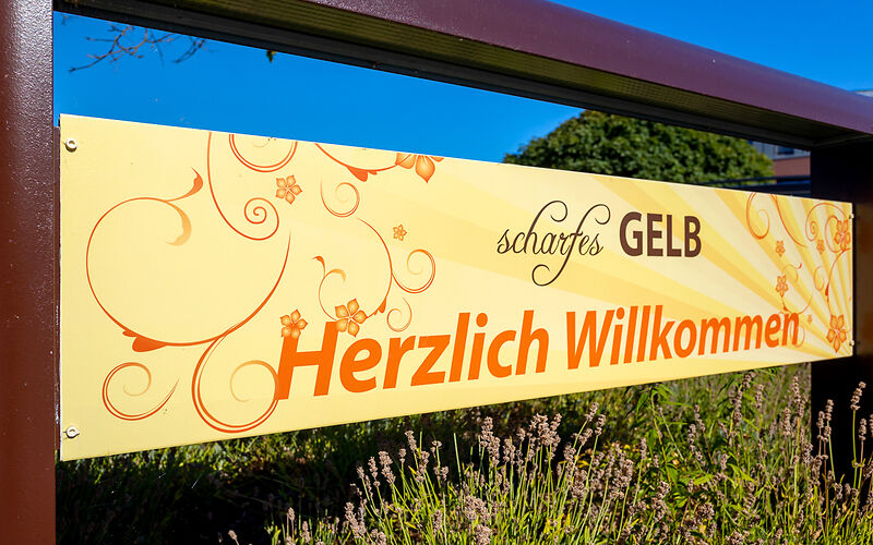 Gelbes Werbeschild mit der Aufschrift 