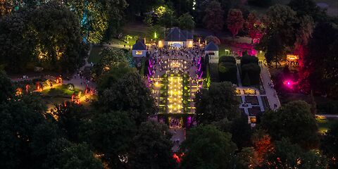 Blick von oben auf den Rosengarten in Forst bei Nacht – farbenfrohe Lichtilluminationen während der Rosengartenfesttagen leuchten thematische Gartenbereiche aus.
