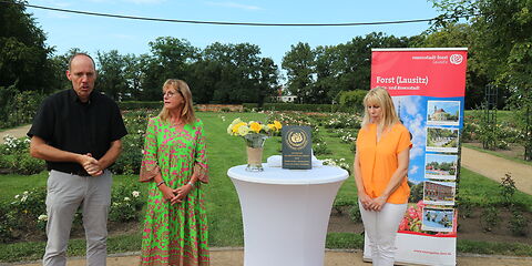 Stefan Palm, Parkmanager dankt Mireille Steil, Vicepräsidentin der Weltrosengesellschaft für die Verleihung der Plakette "Award of Garden Excellence" 