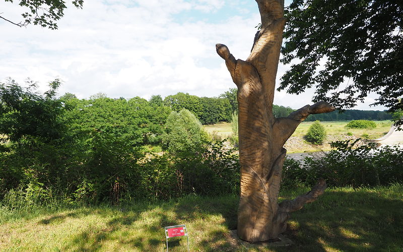 eine Holzskulptur steht im Grünen